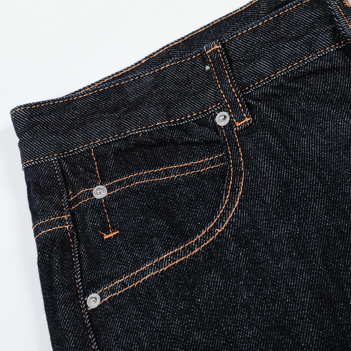 Close-up of front pocket and waistband on dark raw denim jeans with copper stitching