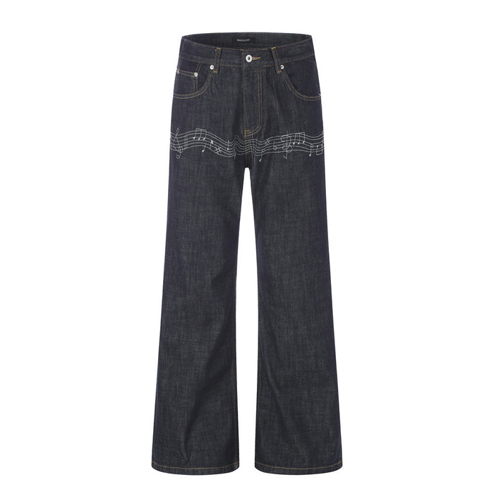 Dark indigo wide-leg raw denim jeans with white embroidered music note and staff detail across the upper leg, front and back