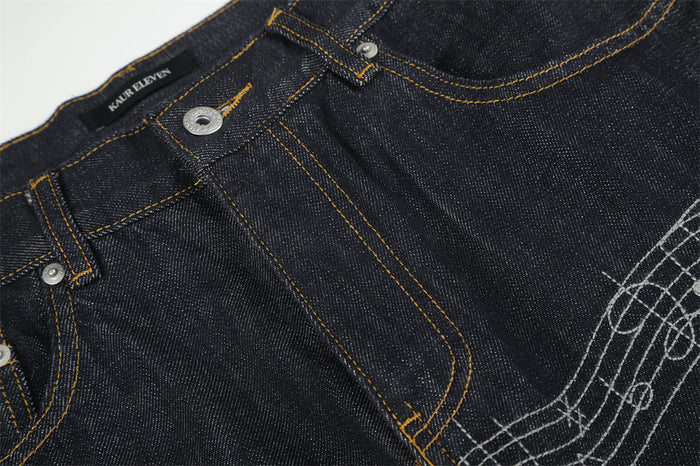 Close-up of front waistband and fly on dark raw denim jeans with yellow topstitching