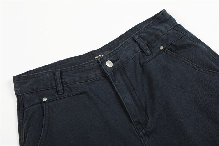 Close-up of navy trousers waistband with button, belt loops, and front pocket seam