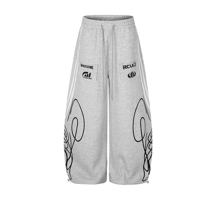 Front view of heather gray wide-leg sweatpants with white side stripes, drawstring waist and black leg graphics