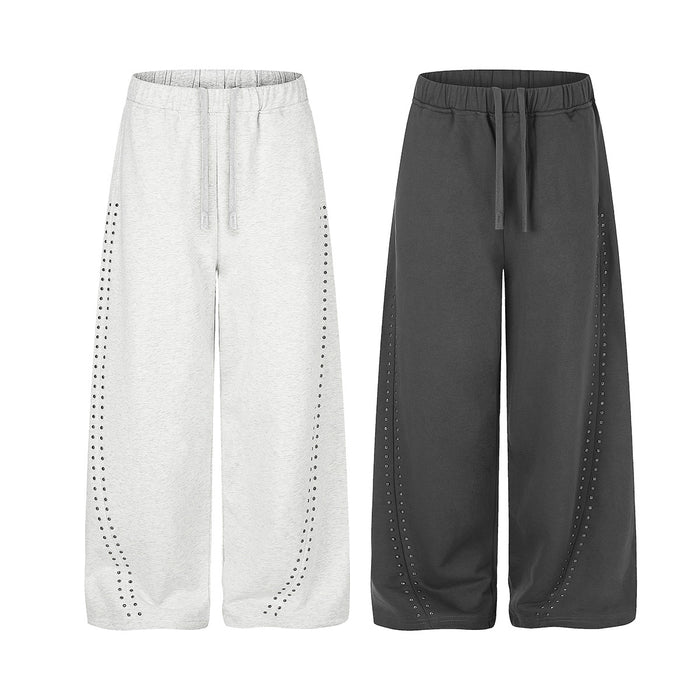 Light gray and black wide-leg sweatpants with elastic waists, drawstrings, and curved rows of side studs