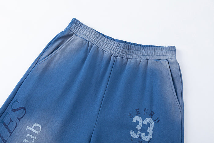 Blue sweatpants waistband and upper front with side pockets, vertical lettering, and a distressed number 33 graphic