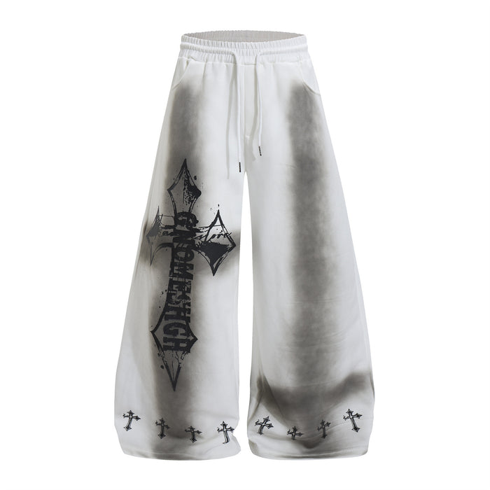 Front view of white wide-leg sweatpants with gray washed shading, gothic cross graphic, and cross-print hems