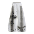 Front view of white wide-leg sweatpants with gray washed shading, gothic cross graphic, and cross-print hems