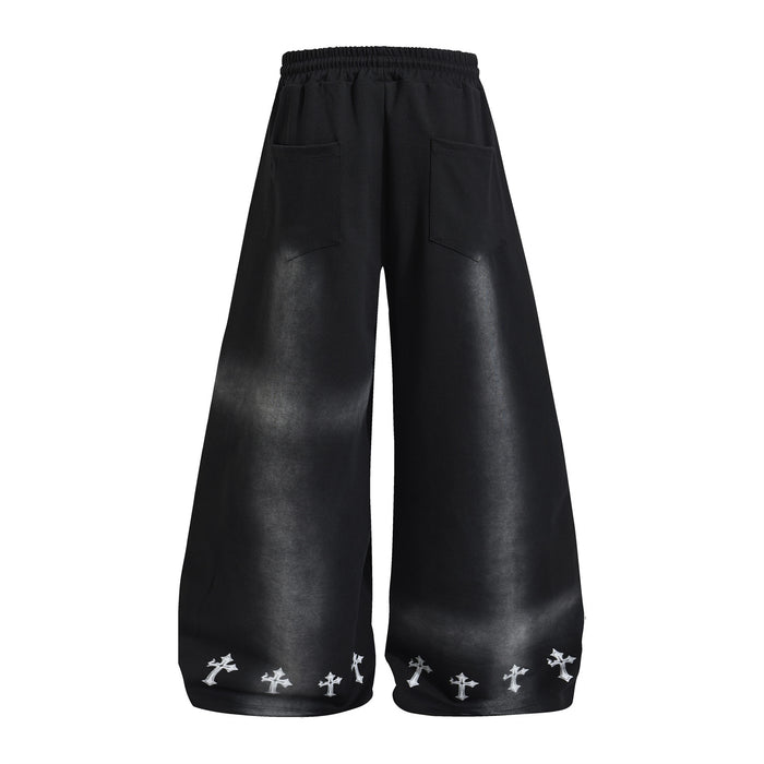 Back view of black wide-leg sweatpants with gray washed shading, rear pockets, and white cross-print hems