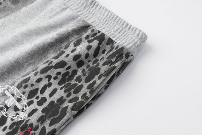 Close-up of the gray waistband and black leopard-print outer leg panel on the sweatpants