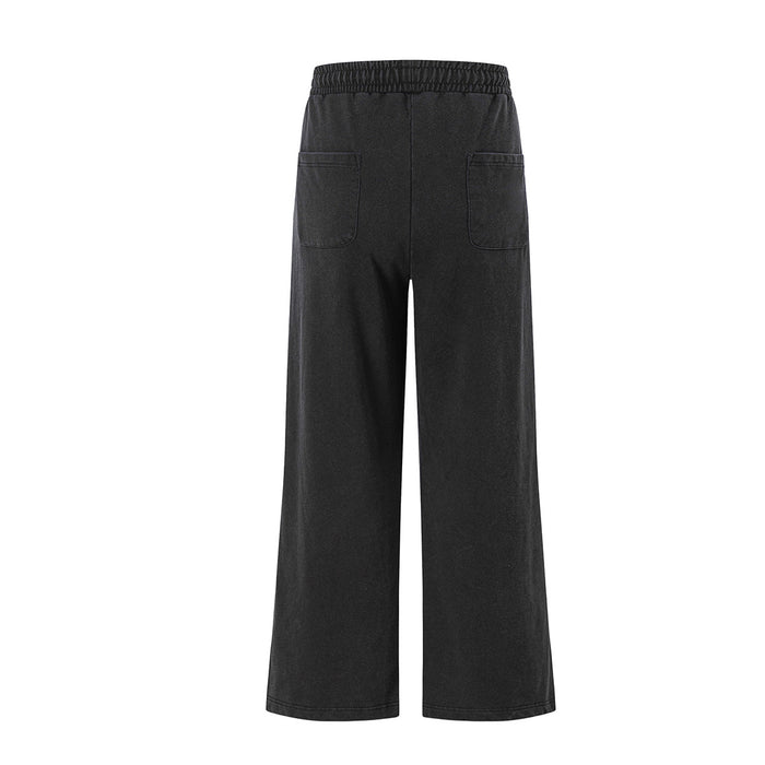 Back view of black wide-leg sweatpants featuring an elastic waistband and two rear patch pockets