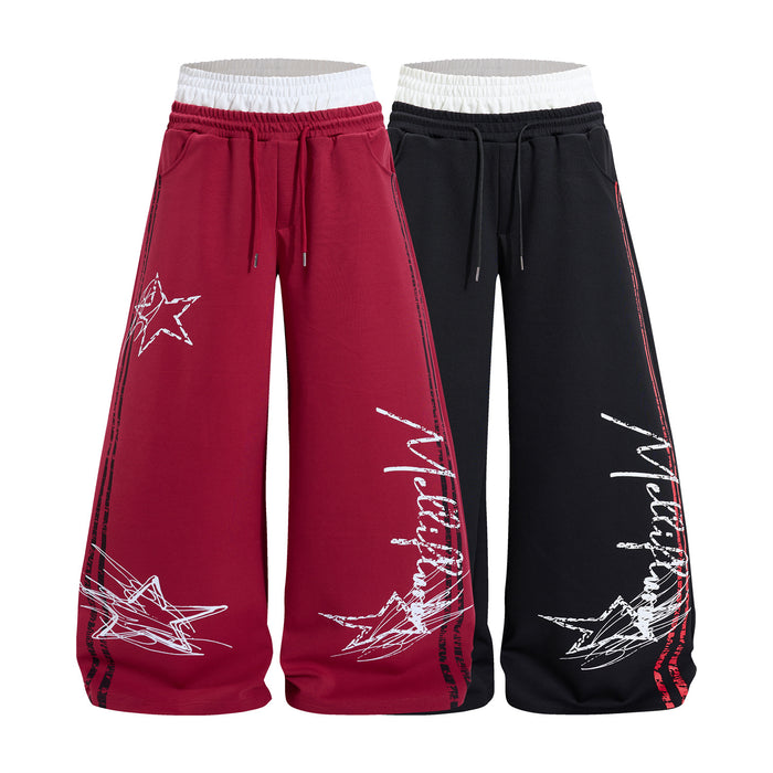 Wide-leg sweatpants with star and graffiti script print, dual white and black waistband, available in burgundy red and black