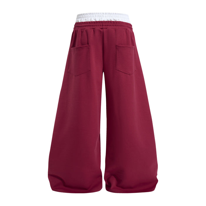 Burgundy wide-leg sweatpants shown from the back with two patch pockets and a white layered waistband