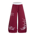 Burgundy wide-leg sweatpants front with white star graffiti graphics, side stripes and drawstring waist