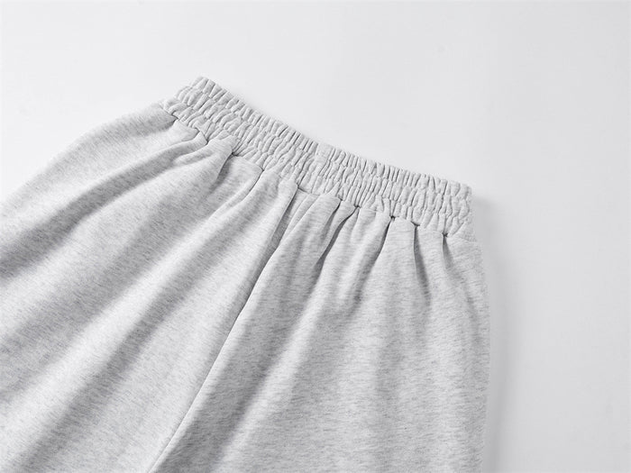 Close-up of the light gray sweatpants’ gathered elastic waistband and soft textured fabric