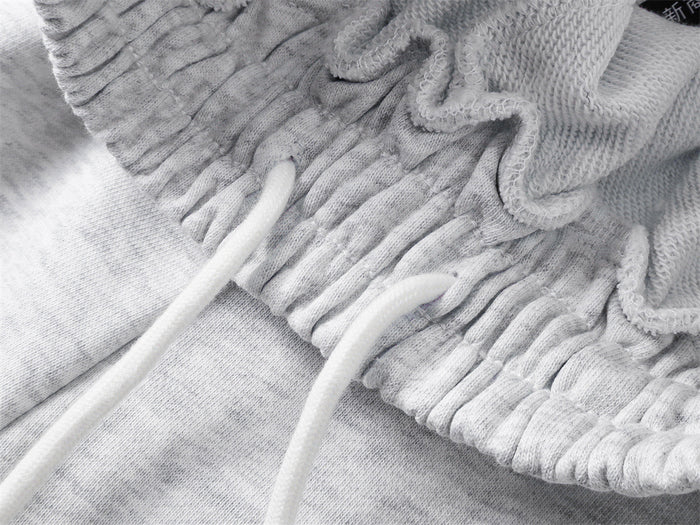 Close-up of the light gray sweatpants waistband showing the inner drawstring and stitched elastic gathers