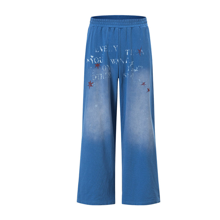 Wide-leg washed blue sweatpants with stencil letter graphic and red star print, elastic waistband, straight leg silhouette