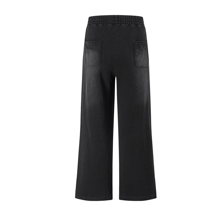 Back view of black wide-leg pants with elastic waistband and two patch pockets
