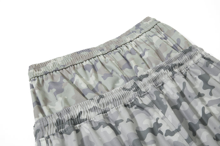 Close-up of gathered waistband on gray camouflage mesh track pants