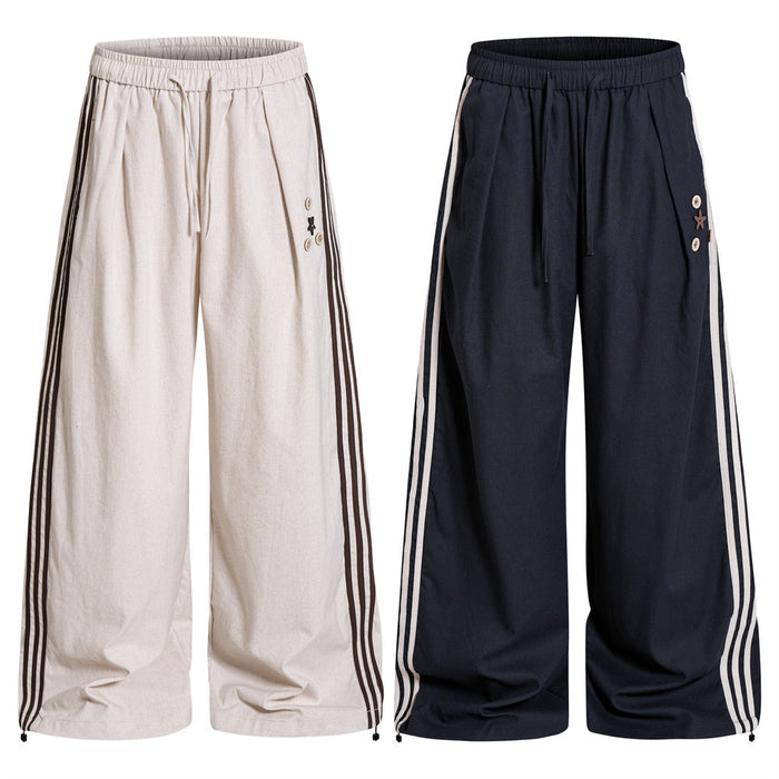 Wide-leg track pants shown front-facing in cream and navy, each with triple side stripes and drawstring waist