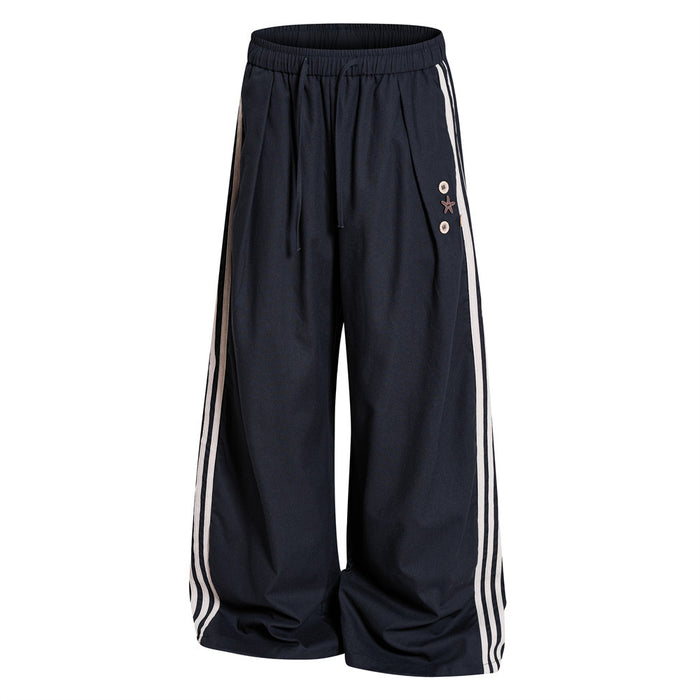 Navy wide-leg track pants angled front view showing wide legs, triple side stripes and elastic drawstring waist