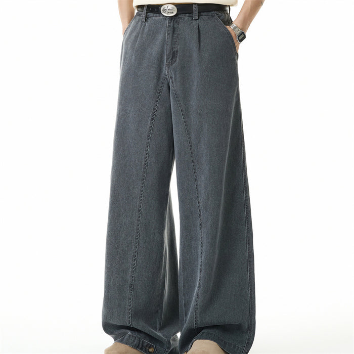 Front view of wide-leg gray denim jeans with pleats and side pockets worn by model