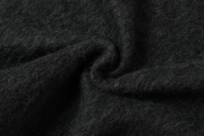 Close-up of the dark wool-blend fabric showing a soft, fuzzy textured weave