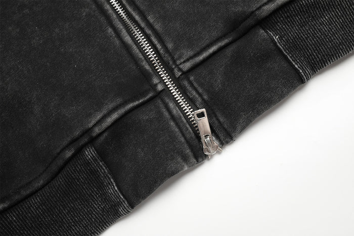 Close-up of the hoodie bottom showing the silver zipper, stitched seam, and ribbed waistband
