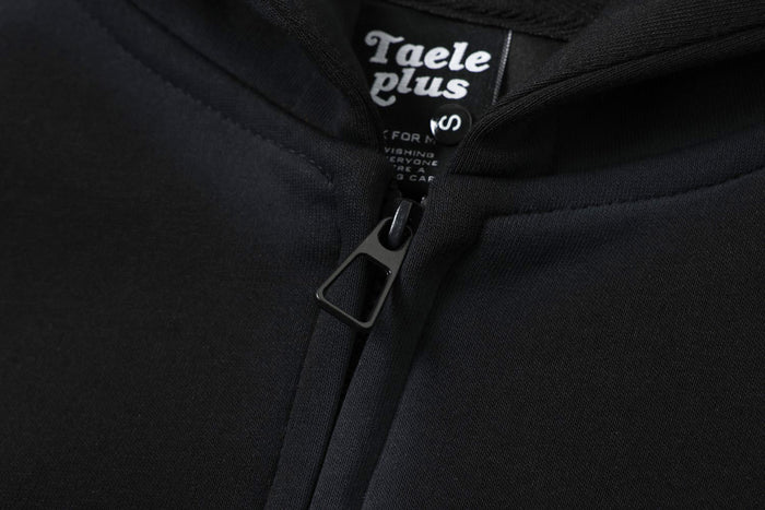 Close-up of black hoodie zipper pull and inner neck label