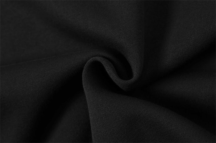 Black hoodie fabric close-up showing smooth knit texture and fold