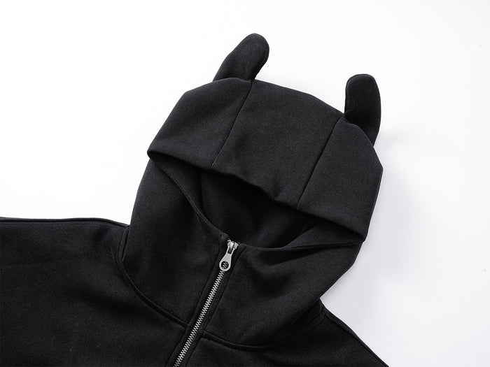 Close-up of black hoodie showing the ear-tipped hood, open face, and silver front zipper