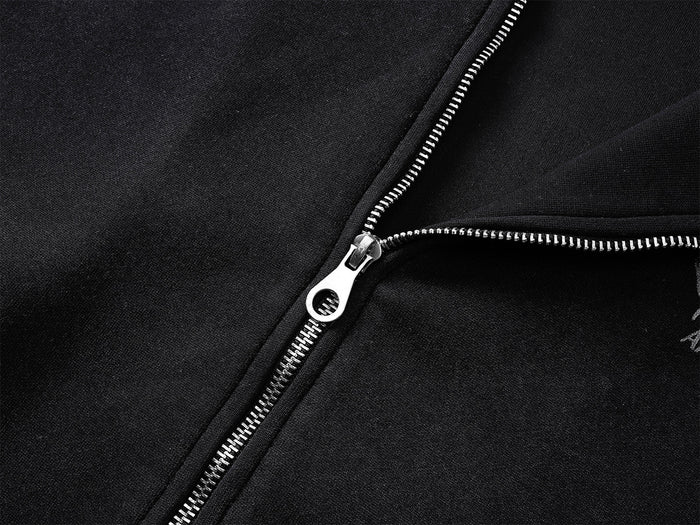 Close-up of black hoodie showing silver zipper teeth, pull tab, and front seam